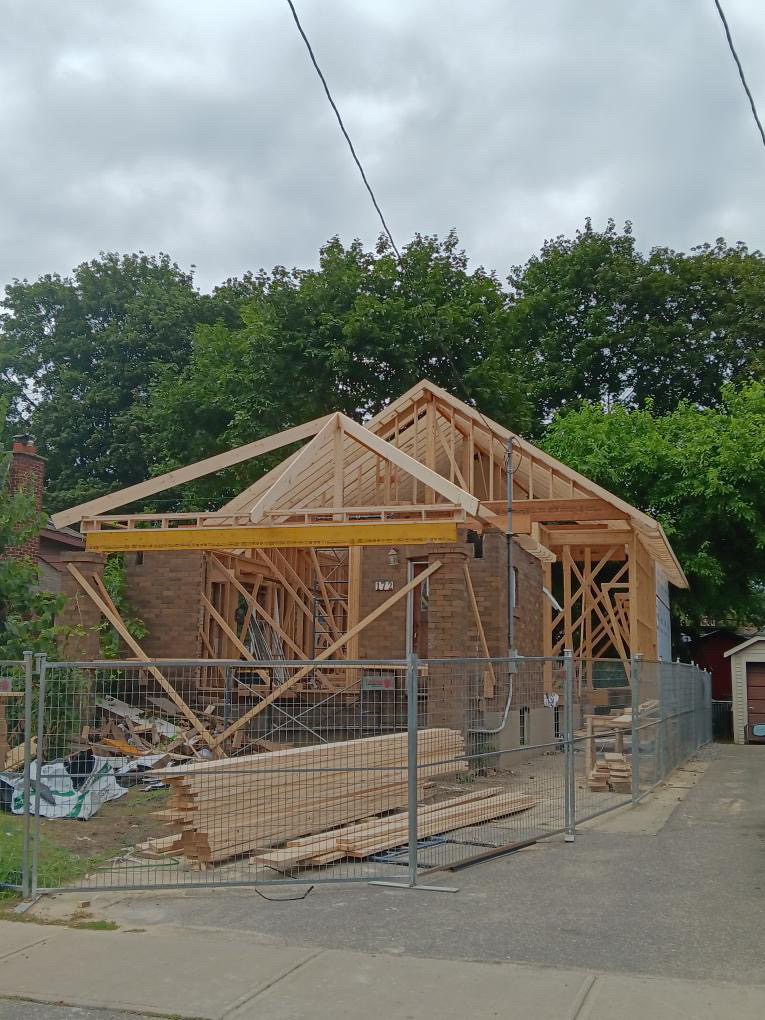 Exposed wood framing and pitched roof of a house under construction
